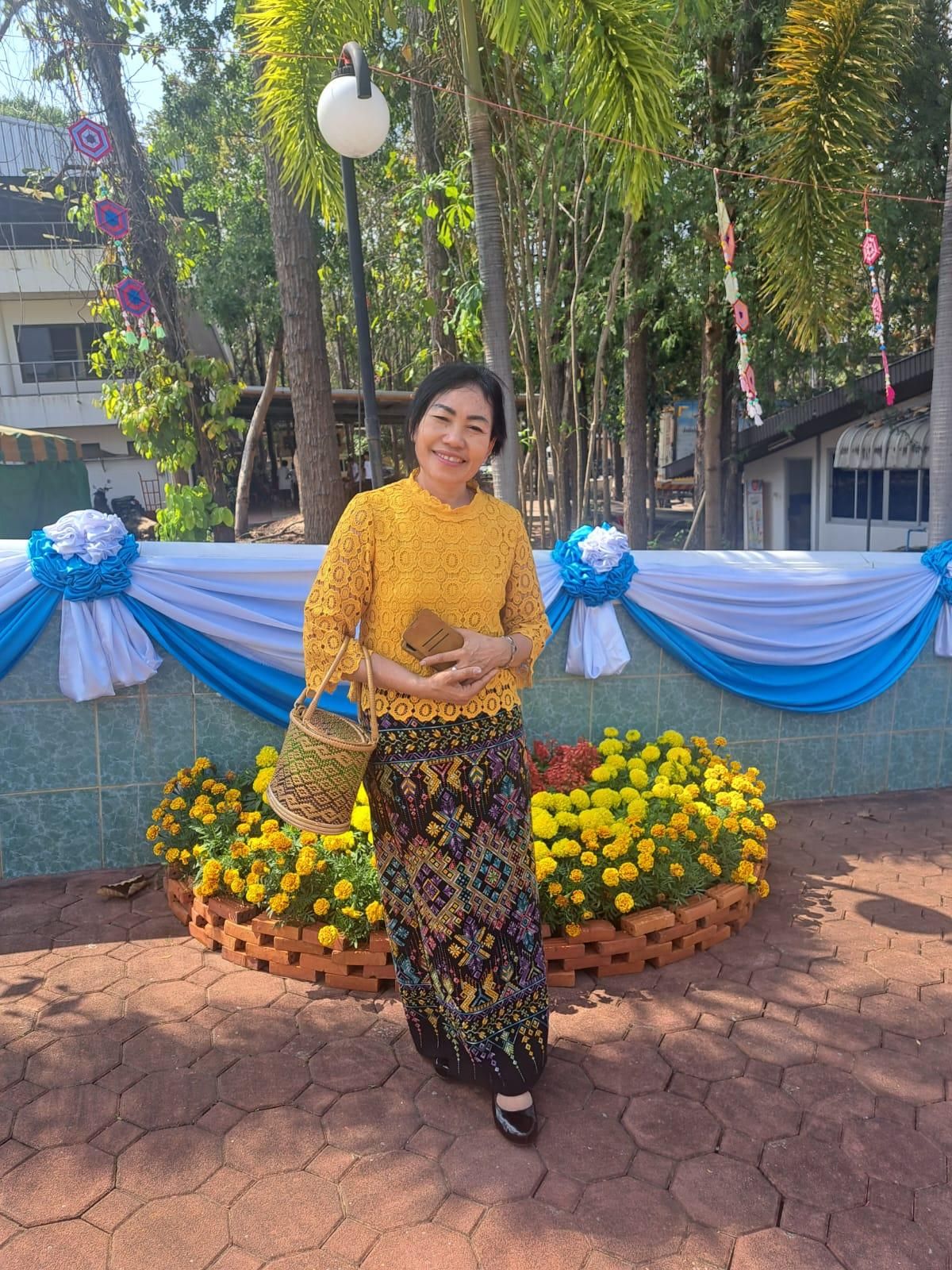 เสื้อลูกไม้สีเหลืองมัสตาร์ดกับผ้าซิ่นลายขิดหลากสี ในงานบุญ