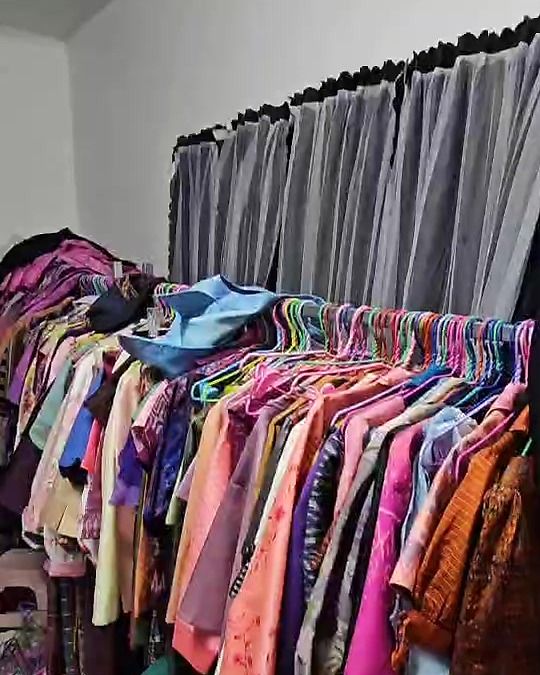 ราวเสื้อผ้าและชุดผ้าไทยในห้องทำงานของร้าน